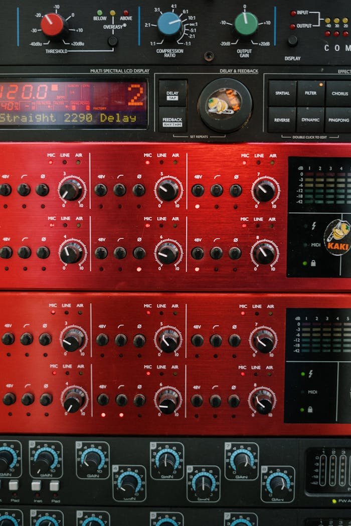 A detailed view of professional audio equipment in a music studio focusing on control panels and dials.
